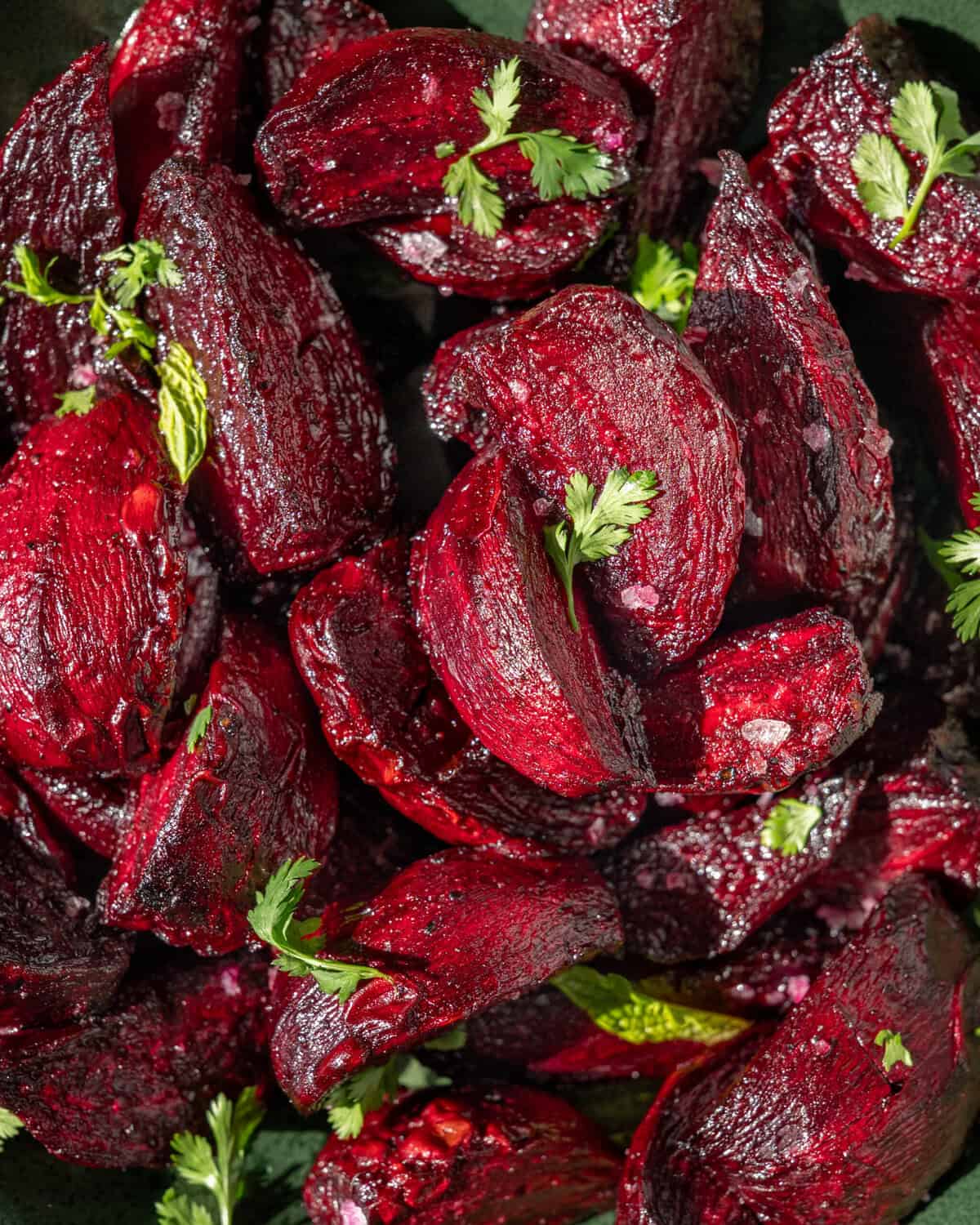 close up of roasted chopped beets with flaky salt and bits of parsley.
