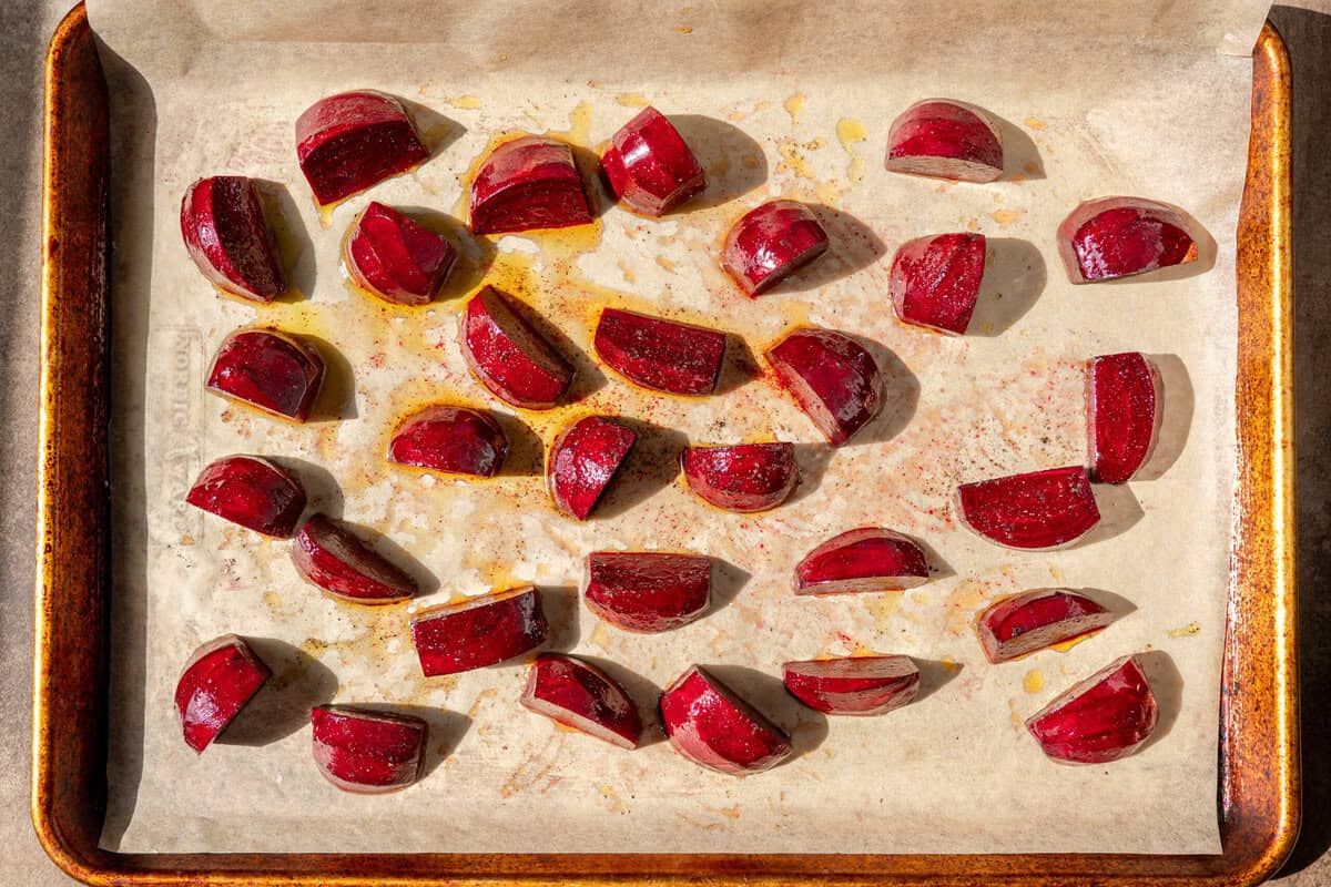sliced beets with oil, salt and pepper on the baking sheet.