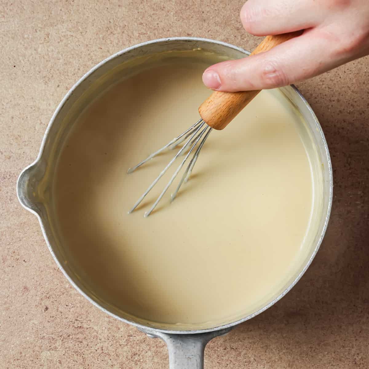 person whisking in the miso-soy sauce slurry.