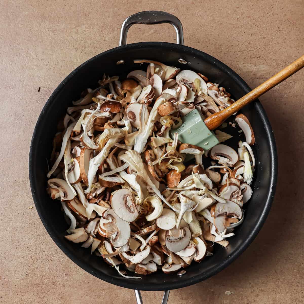 mushrooms added to shallots in pan.