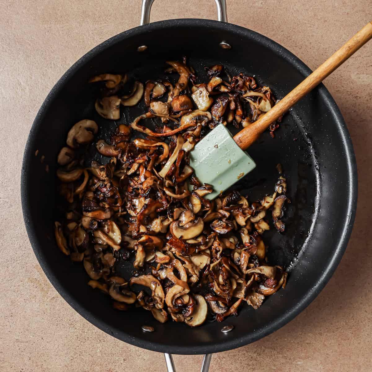 cooked mushrooms and shallots in pan.