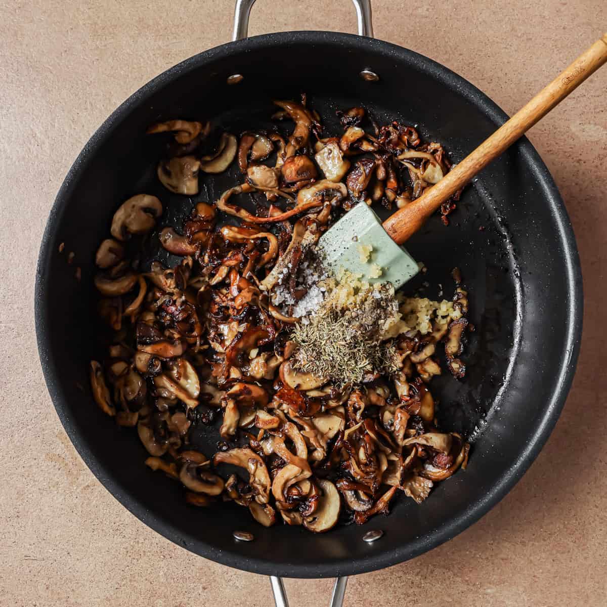 garlic, thyme, kosher salt, and pepper added to cooked shallots and mushrooms.