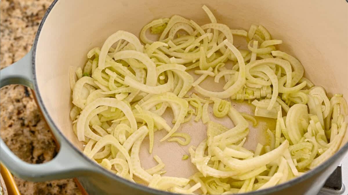 olive oil and sliced fennel sauteeing in a pot.