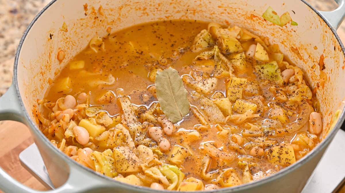 vegetable broth, bay leaf, 1 tsp kosher salt, and black pepper added to the pot.